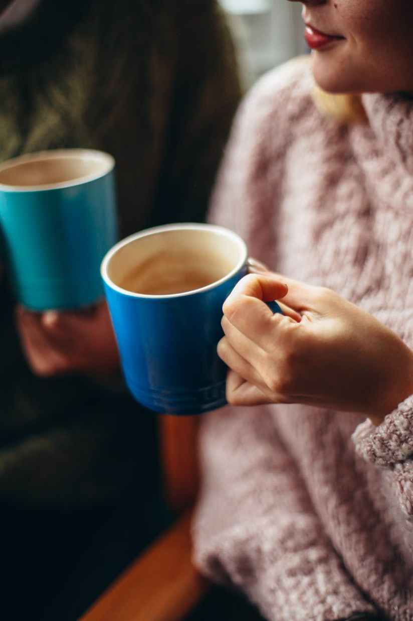 photo of woman holding cup of coffee